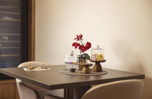 a table with chairs and a table with flowers on it at Soul of Trento Vicolo del vo' in Trento