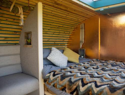 ein Schlafzimmer mit einem Bett in einem Zimmer in der Unterkunft 'Cinnabar Nest' Remote Off-Grid Eco Cabin in Sedgefield