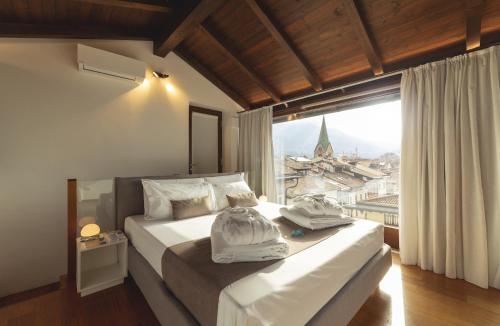 sypialnia z dużym łóżkiem i dużym oknem w obiekcie Hi room vicolo del vò w Trydencie