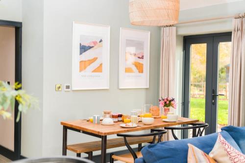 a living room with a table and a blue couch at Appletree - a newly converted luxury barn in Warwickshire on our farm in Evesham