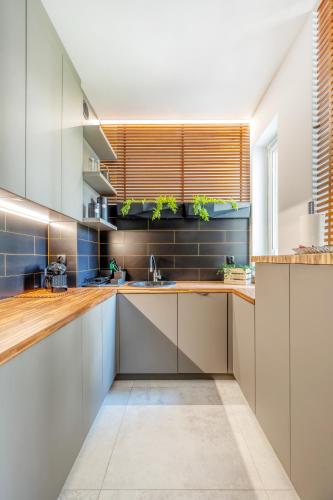a kitchen with white cabinets and blue tiles at Łódź Retreat Apartments - Parking, Terrace & Garden - by Rentujemy in Łódź