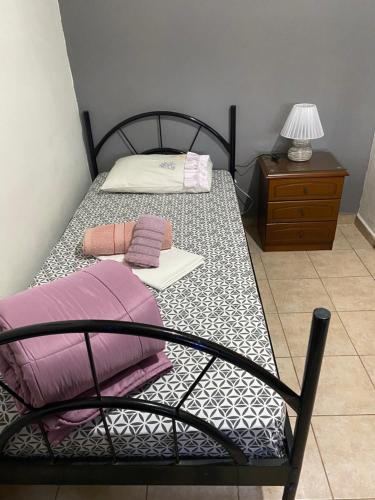 a bedroom with two beds and a table with a lamp at George Garden in Nea Michaniona