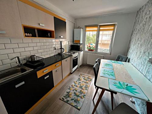 a kitchen with a table and a counter top at Green Apartament in Sovata