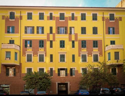 un bâtiment jaune avec beaucoup de fenêtres dans l'établissement Hostel Cosmos, à Rome