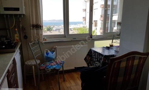 a kitchen with a table and chairs and a table and windows at Bostanci cozy excellent location flat in Istanbul