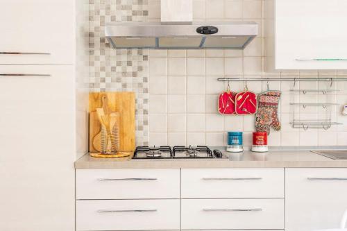 a kitchen with white cabinets and a stove top oven at Stella Marina in Scilla
