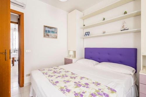 a bedroom with a large bed with a purple headboard at Stella Marina in Scilla