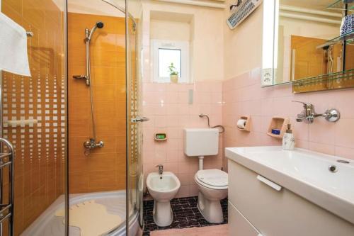 La salle de bains est pourvue de toilettes, d'un lavabo et d'une douche. dans l'établissement Home away from home, à Šmrika