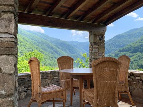 a table and chairs on a patio with a view of mountains at Magic Mola in Zeri