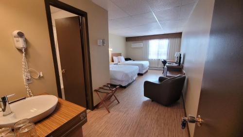 a hotel room with a bathroom with a sink and a mirror at Hôtel Aquamer in Carleton sur Mer