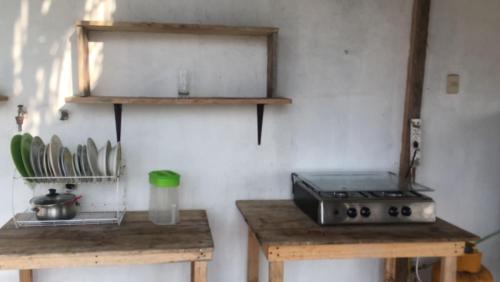 een keuken met 2 houten tafels en een fornuis bij Caracola, habitación privada de Flor de Lis Beach House in Playas