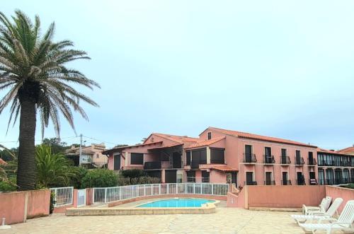 une maison avec un palmier et une piscine dans l'établissement Petit appartement à 50m à pied de la mer, à Fréjus