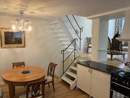 a kitchen and dining room with a table and a staircase at La Maison des Sources in Brussels
