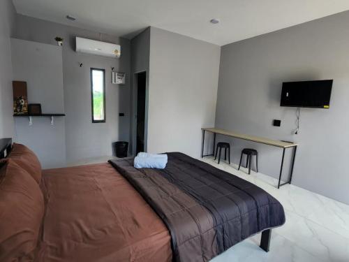 1 dormitorio con 1 cama grande y escritorio en เช็คอินรีสอร์ท ชัยนาท en Ban Khao Khayai (1)