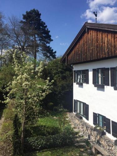 a white building with a wooden roof next to a tree at Historisches Refugium in der Altstadt von Ebersberg in Ebersberg