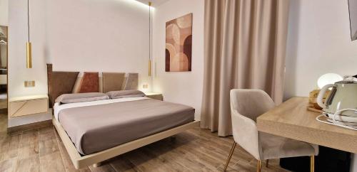 a bedroom with a bed and a table and a desk at BeB Altomare in Lampedusa