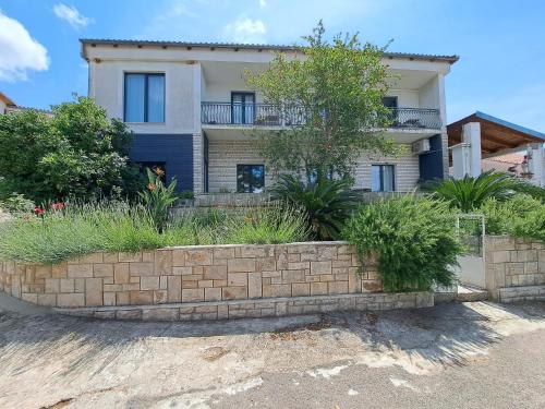 a house with a retaining wall in front of it at Guesthouse Tamara in Lovište