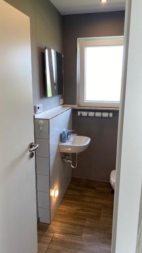 a bathroom with a sink and a window at Ferienhaus Herger in Niendorf