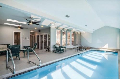 a swimming pool in a house with chairs and a table at 3 bedroom w indoor pool hotub in Silver Spring