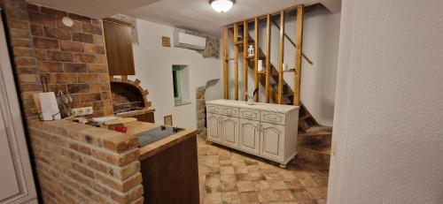 cocina con fregadero y pared de ladrillo en Andrijana en Vrbnik