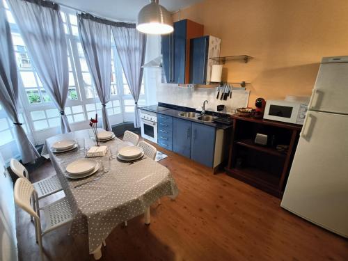 Rianjo的住宿－Trisquel Rianxo，厨房配有桌椅和冰箱。