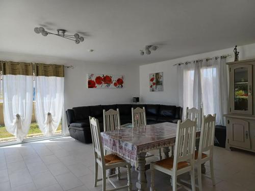 une salle à manger avec une table, des chaises et un canapé dans l'établissement VILLA VACANCES MER et PLAGES Près ROYAN LA CHRYSOLIGE, à Meschers-sur-Gironde