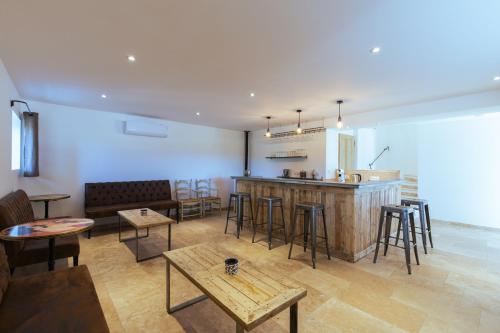 a room with a bar and some chairs and tables at Chambres & Tables d'hôtes Moulin de Lavon in Gargas