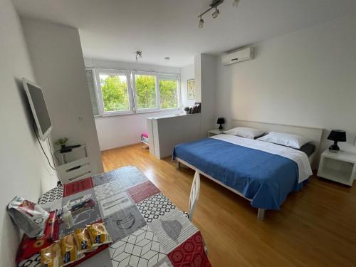 ein Schlafzimmer mit einem Bett und einem Tisch darin in der Unterkunft Apartment Busic in Split in Split