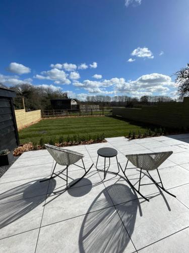 two chairs and a table on a patio at Hailes - a newly converted barn on our farm between Stratford upon Avon and the Cotswolds in Evesham