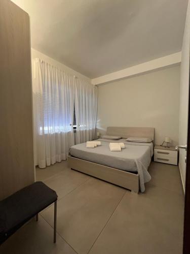 um quarto branco com uma cama e uma janela em Mare a KmZERO em Gallipoli