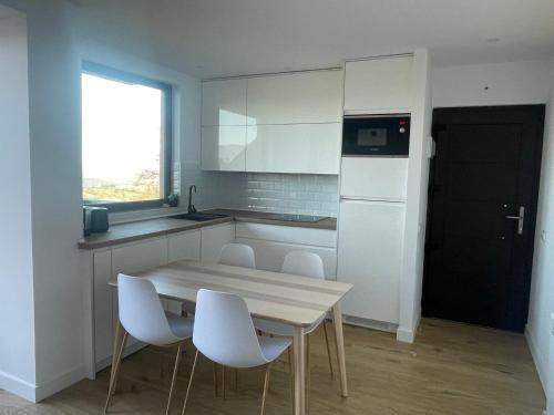 eine Küche mit einem Tisch und Stühlen sowie einem Kühlschrank in der Unterkunft Mirador de Canales in Canales