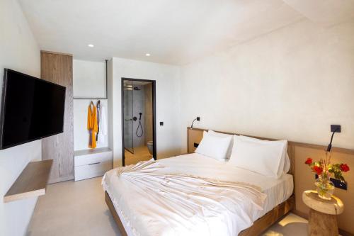 a bedroom with a large bed and a tv at Dedalos Touch Boutique Hotel in Skaleta
