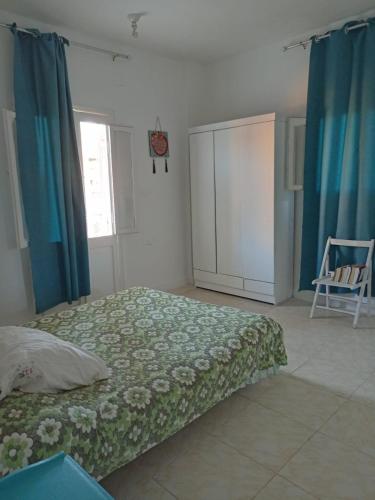 a bedroom with a bed and blue curtains at فيلا باب البحر in Marsa Matruh