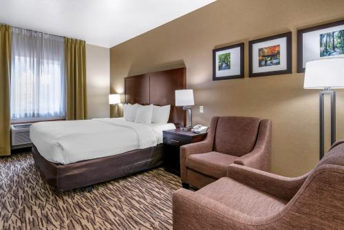 a hotel room with a bed and a chair at Comfort Suites Portland Airport in Portland