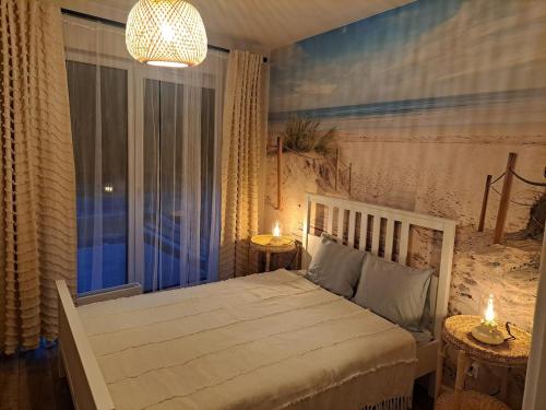 a bedroom with a white bed and a window at Willa la Maddalena apartament in Unieście