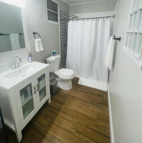 ウマカオにあるHome for your stayの白い洗面台とトイレのあるバスルーム