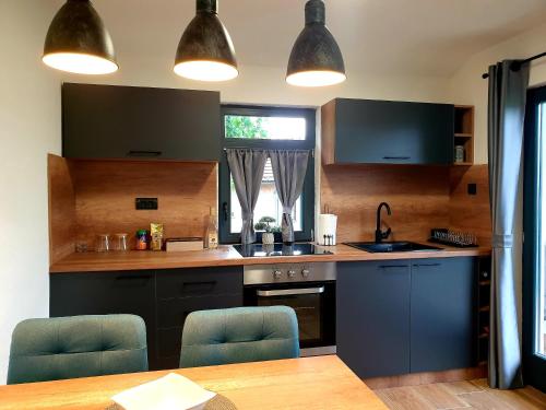 a kitchen with blue cabinets and a table and chairs at Apartmani Višegradski pogled in Višegrad