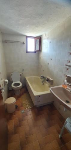 a bathroom with a tub and a toilet and a sink at Villa Ourania in Troulos