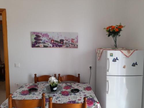 a kitchen with a table and a white refrigerator at Kate House in Agioi Apostoli