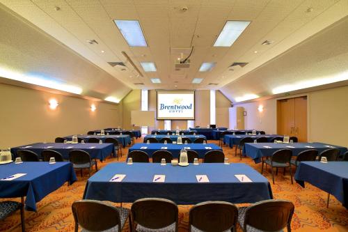 a conference room with blue tables and chairs and a screen at Brentwood Hotel in Wellington