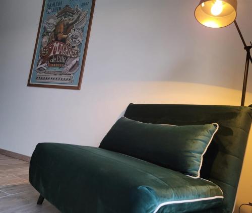 un divano verde in una stanza con lampada di Air marin a La Bernerie-en-Retz