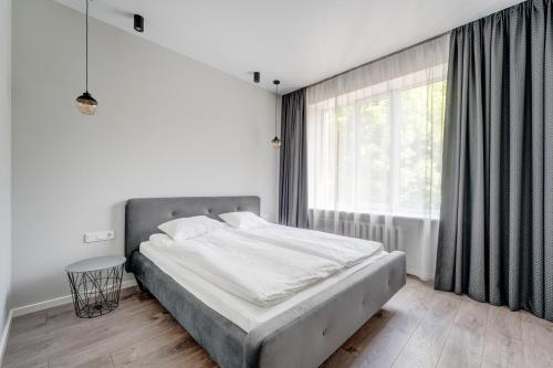 a bedroom with a bed and a large window at KALVARI APARTMENTs in Vilnius