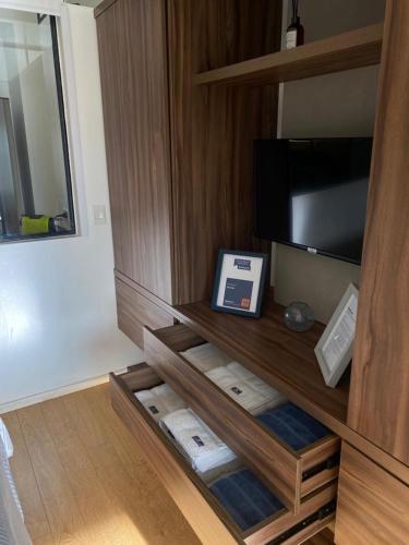 a room with a cabinet with a television and towels at Puravida DOHO cerca de todo in Buenos Aires