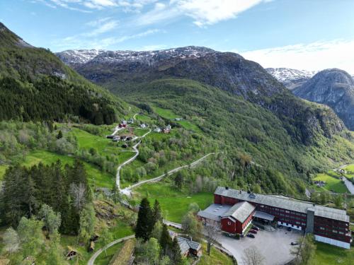 a building in the middle of a valley with mountains at Stalheim Fjord og Fjellhytter in Stalheim