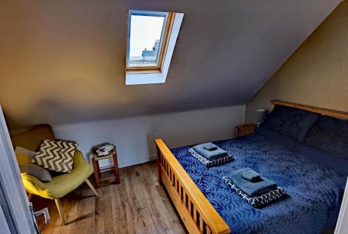 Habitación pequeña con cama y ventana en Cozy Loft In The Heart Of Kirkwall, en Islas Orcadas