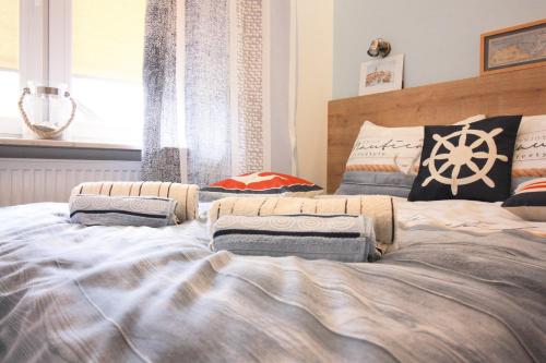 a bedroom with a large bed with pillows on it at Apartamenty u Rybaka in Jastarnia