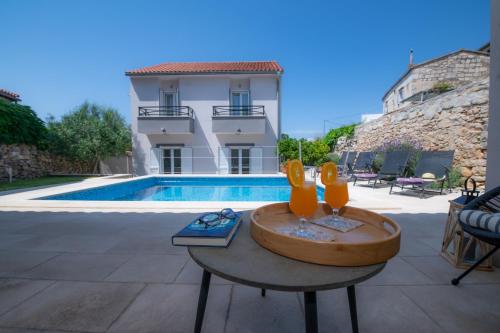 eine Villa mit einem Pool und einem Tisch mit einem Brunnen in der Unterkunft Villa Mediterana in Vis