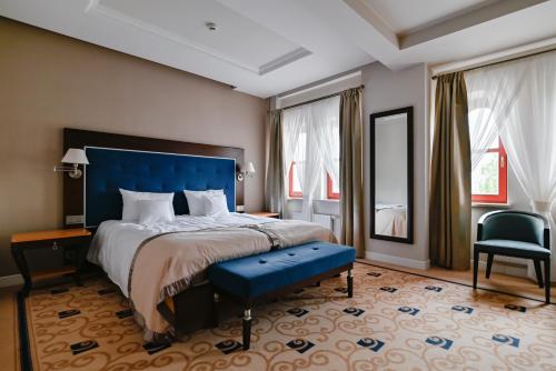 a bedroom with a large bed with a blue headboard at Villa Garden Dyplomat in Olsztyn