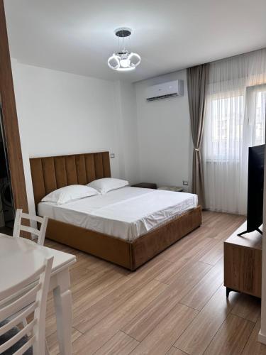 a bedroom with a bed and a table and a tv at Studio City Center in Tirana