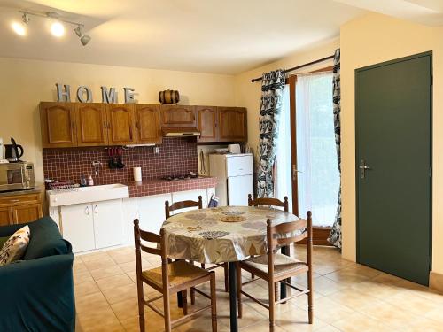 een keuken met een tafel en stoelen in een kamer bij Gîte Fuchsia in Carlux